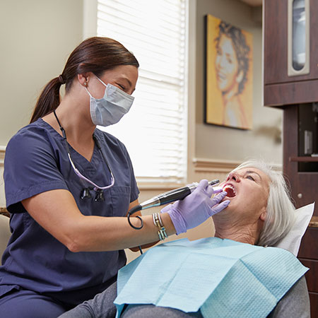Dentist working with female patient giving dental crowns in Woburn, MA. 
