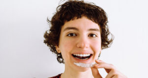 Young girl getting ready to place a clear aligner into her mouth